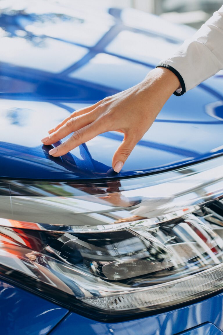 Female hands touching new blue car close up